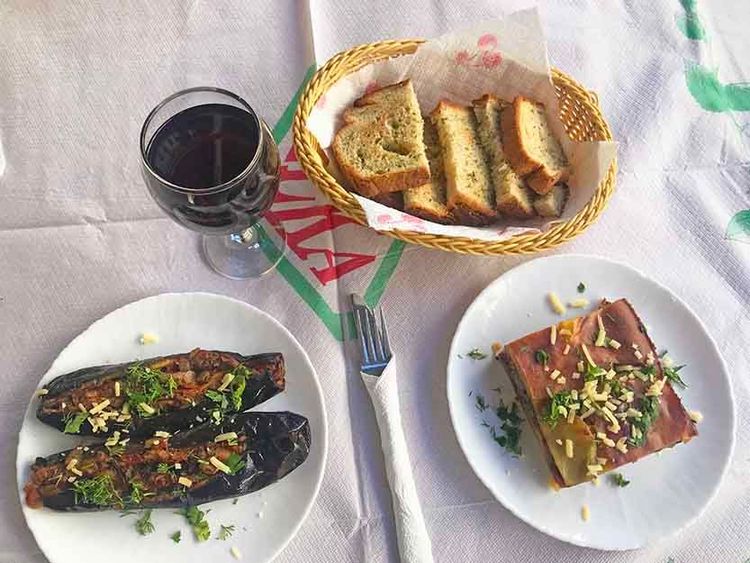 Un déjeuner typique à Gjirokastër (des aubergines farcies, une moussaka, un verre de vin rouge local)