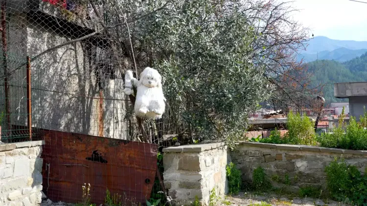 Une peluche accrochée au clôture, la ville de Permet, l'Albanie Une peluche accrochée au clôture, la ville de Permet, l'Albanie