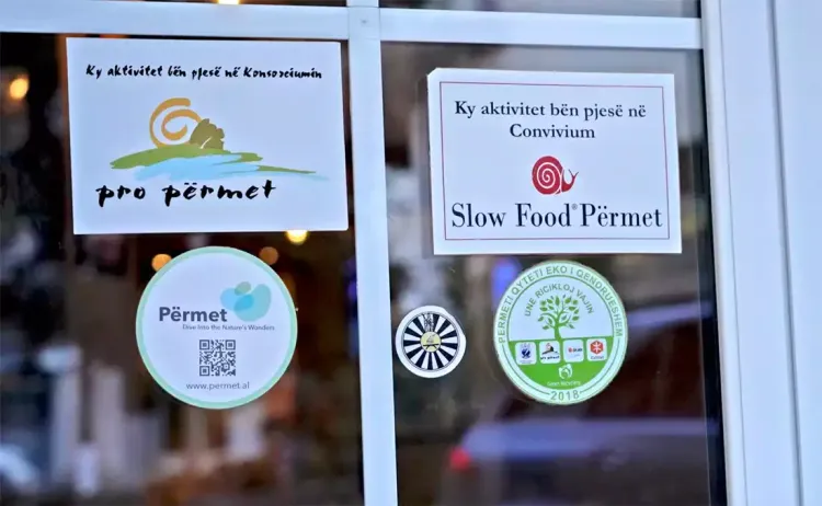 Le label "Slow food" sur une porte d'un restaurant à Permet